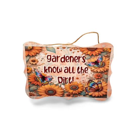 Decorative sign with floral design and 'gardeners know all the dirt!' text on a white background