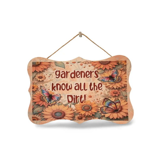 Decorative sign with floral design and text 'Gardeners know all the dirt' on a white background