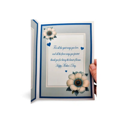 Greeting card with floral design and Mother's Day message, held open by a hand.