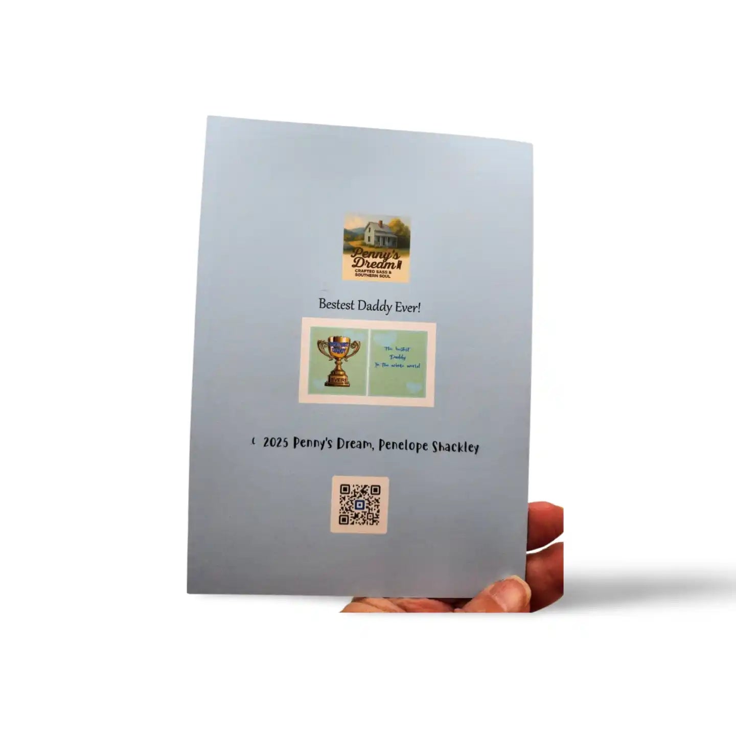Gray greeting card with printed images and text held by a hand on a white background