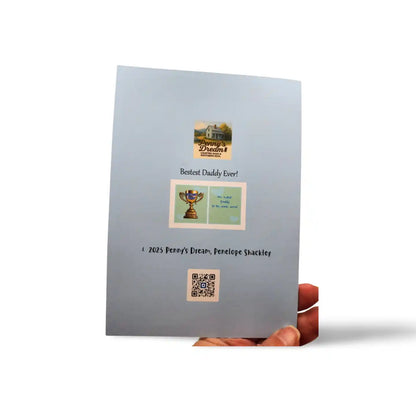 Gray greeting card with printed images and text held by a hand on a white background