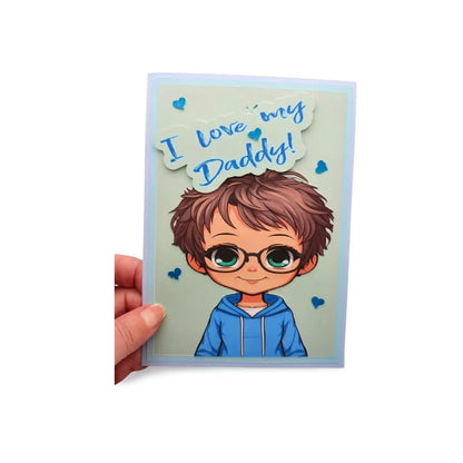 Card with cartoon character and 'I love my Daddy!' text held by a hand on a white background