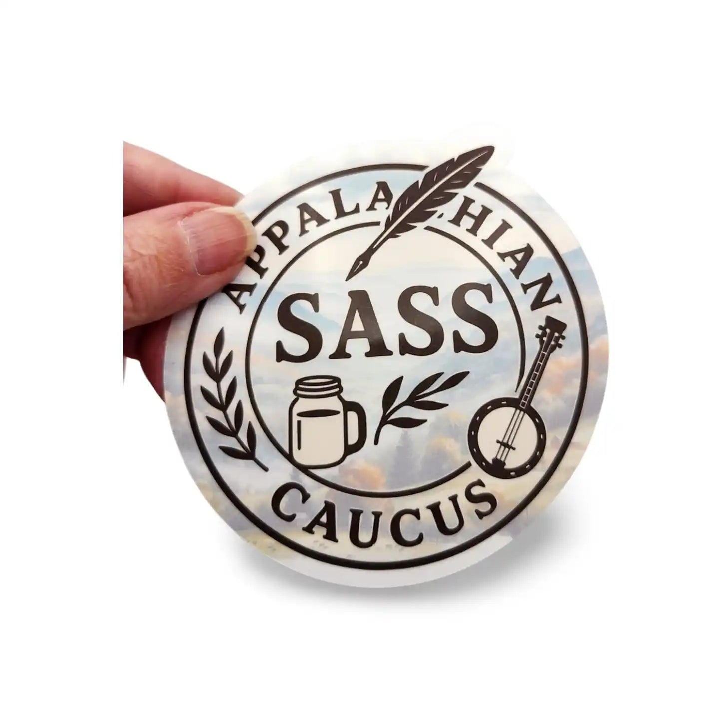 Round sticker with 'Appalachian Sass Caucus' text and graphics held by a hand on a white background