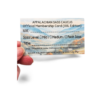 Appalachian Sass Caucus membership card held by a hand with mountain background