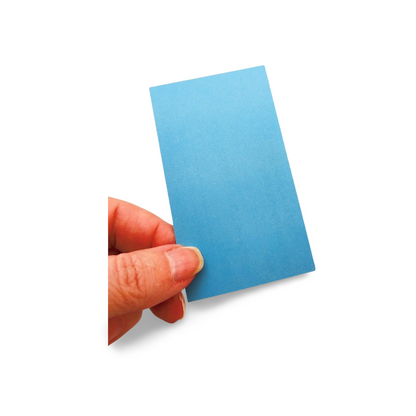 Hand holding a small blue card against a white background