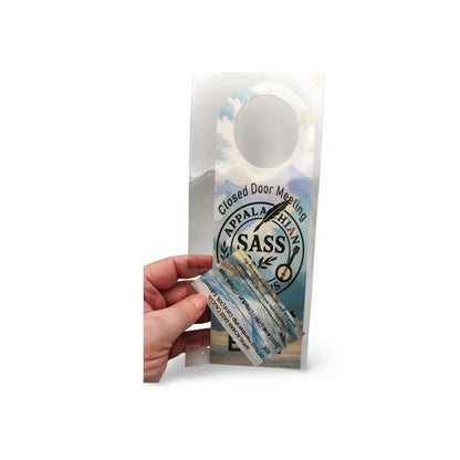 Hand holding a door hanger with 'Appalachian SASS' branding on a white background