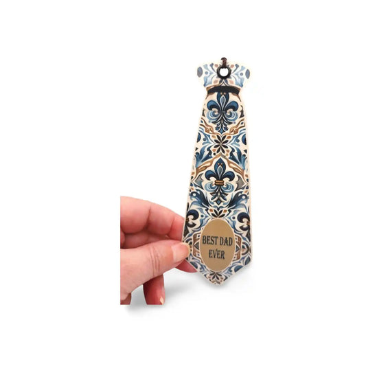 Decorative tie with floral pattern and 'Best Dad Ever' text held by a hand on a white background