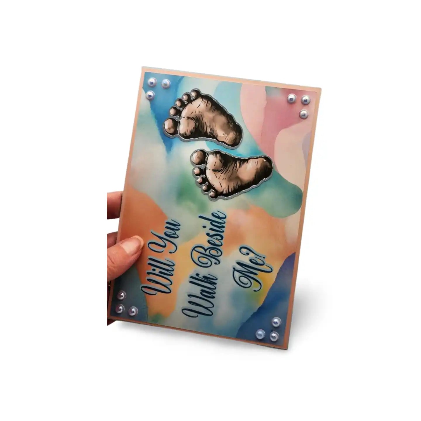 Card with footprints and text 'Will You Walk Beside Me?' held by a hand on a white background