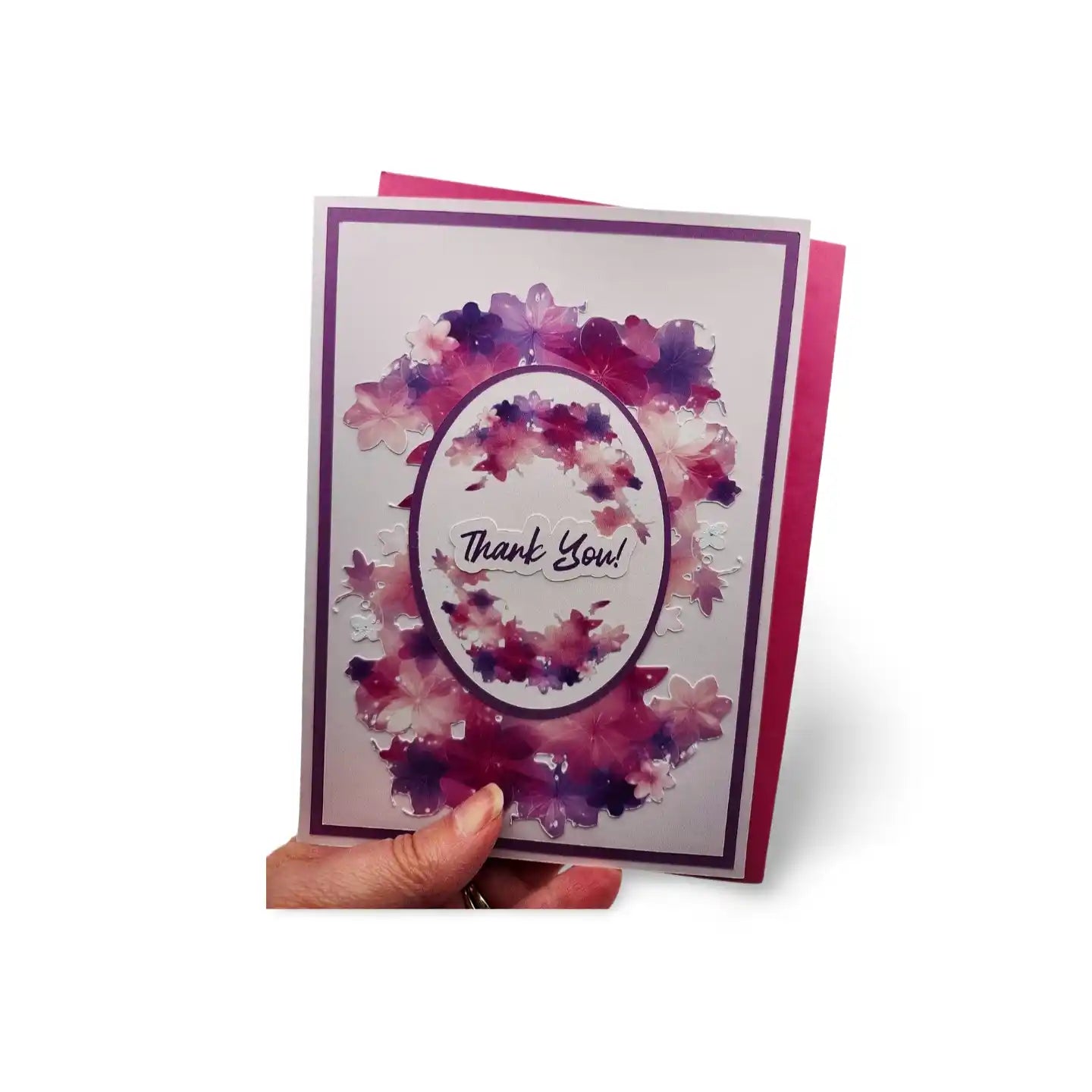 Greeting card with watercolor design and 'Thank You!' text held by a hand on a white background