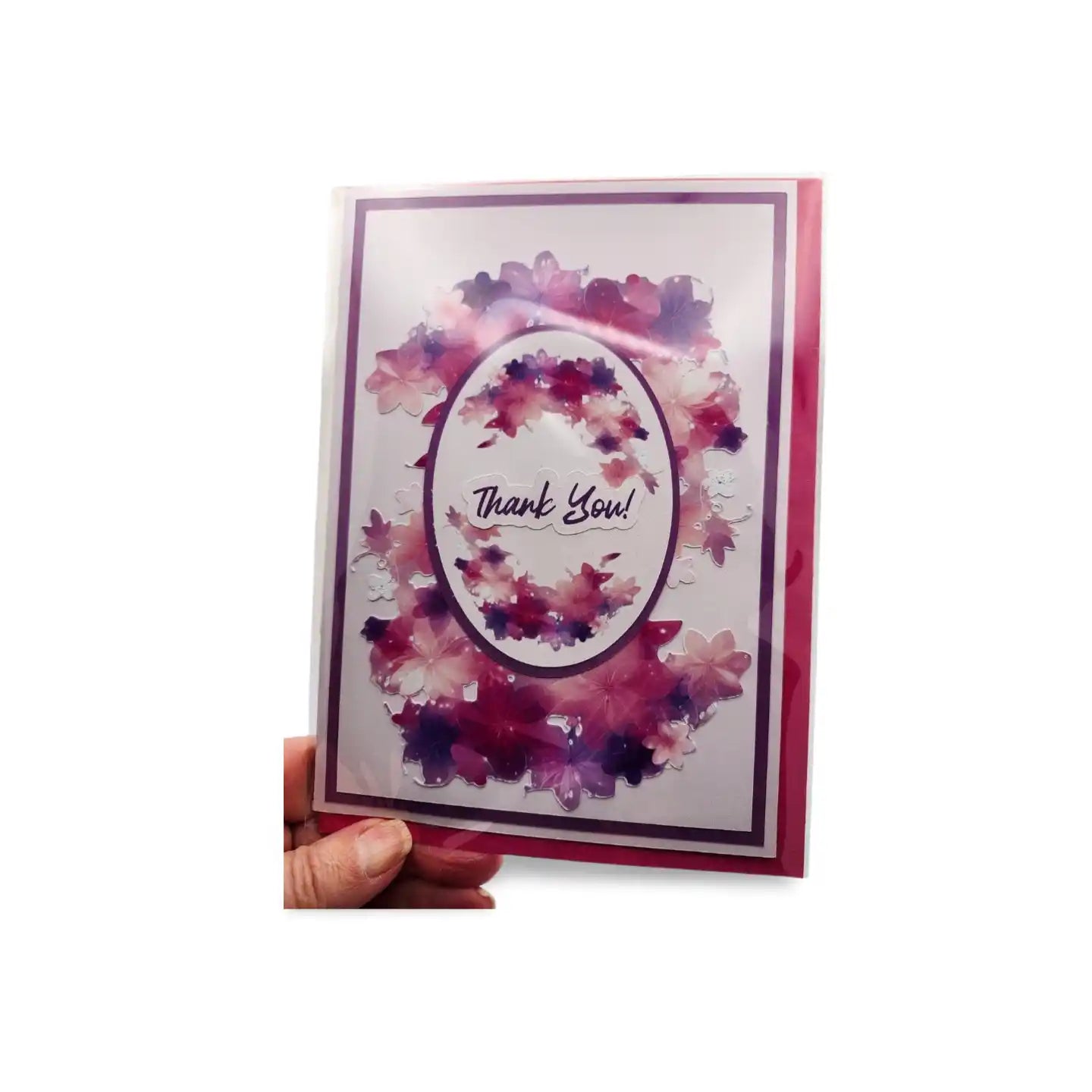 Card with watercolor design and 'Thank You' text held by a hand on a white background