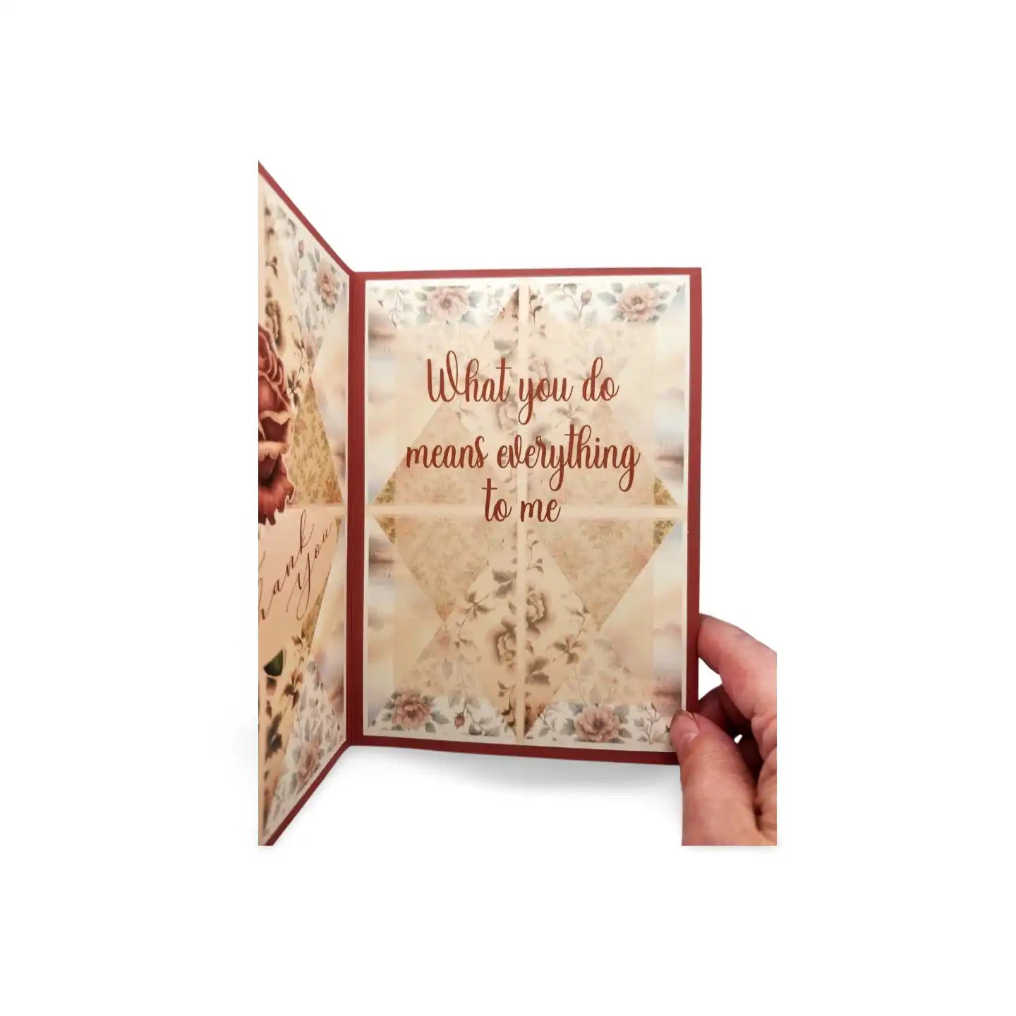 Greeting card with floral design and text held by a hand on a white background