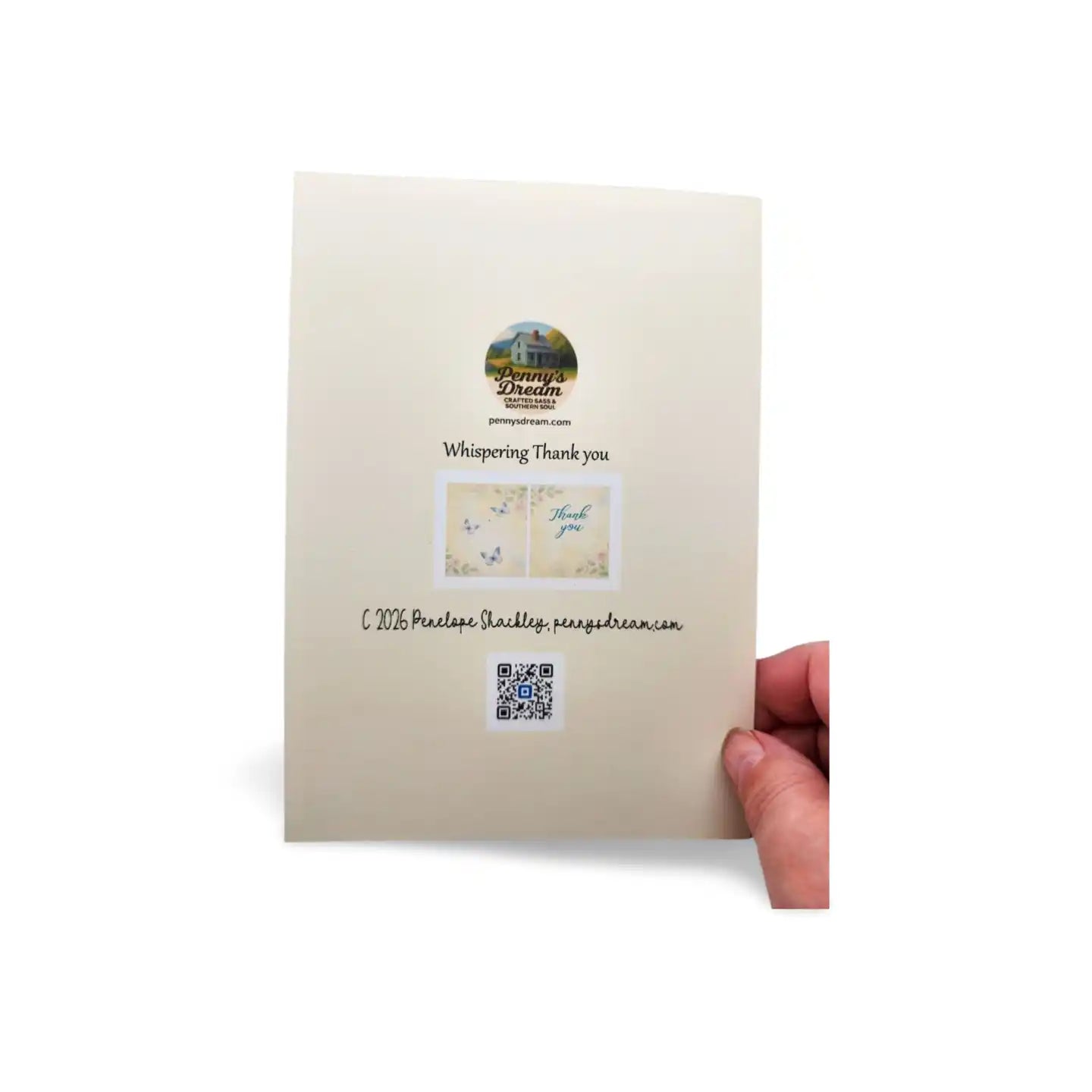 Beige greeting card with a QR code and text held by a hand on a white background