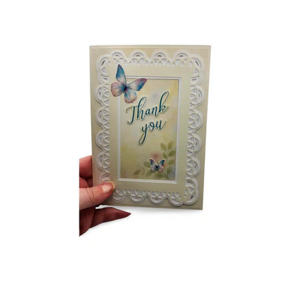 Card with 'Thank you' text and butterfly design held by a hand on a white background