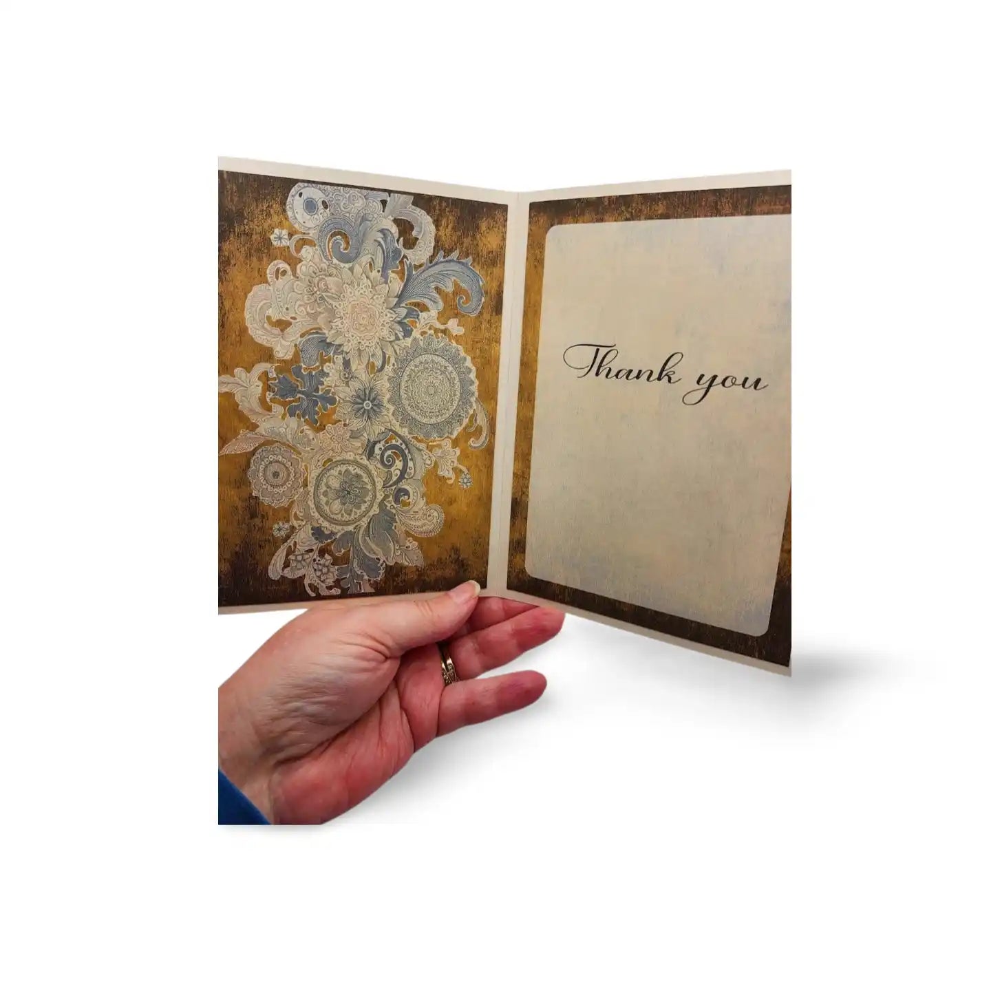 Hand holding a decorative card with floral design and 'Thank you' text on a white background
