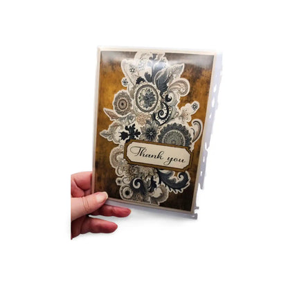 Decorative card with paisley design and 'Thank you' text held by a hand on a white background