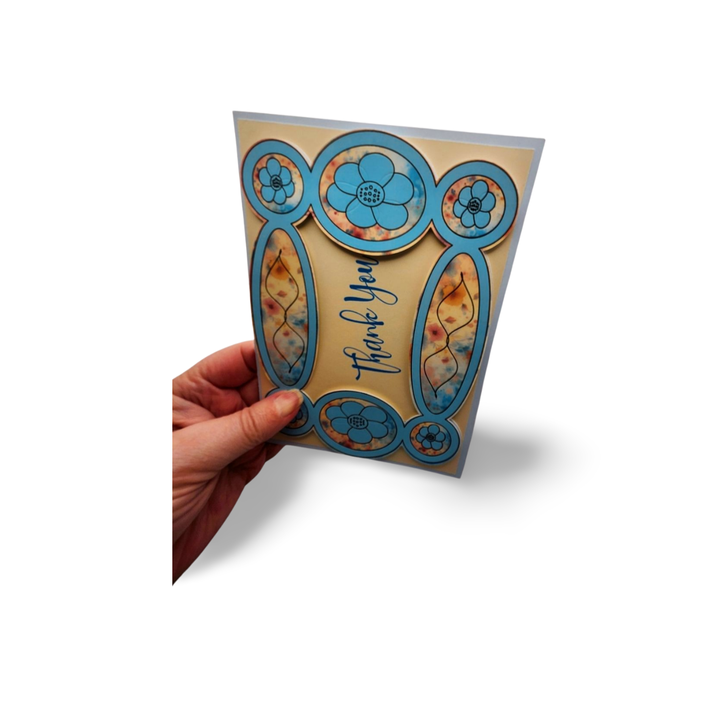 Hand holding a card with floral design and 'Thank you' text on a white background