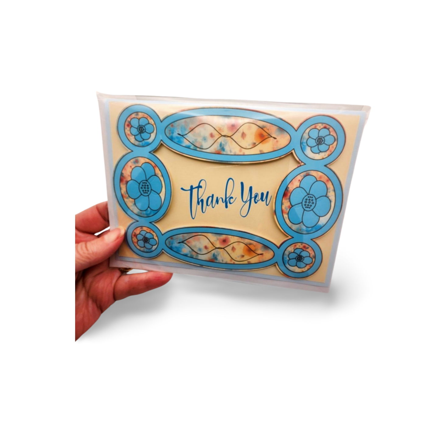 Hand holding a card with floral designs and 'Thank You' text on a white background