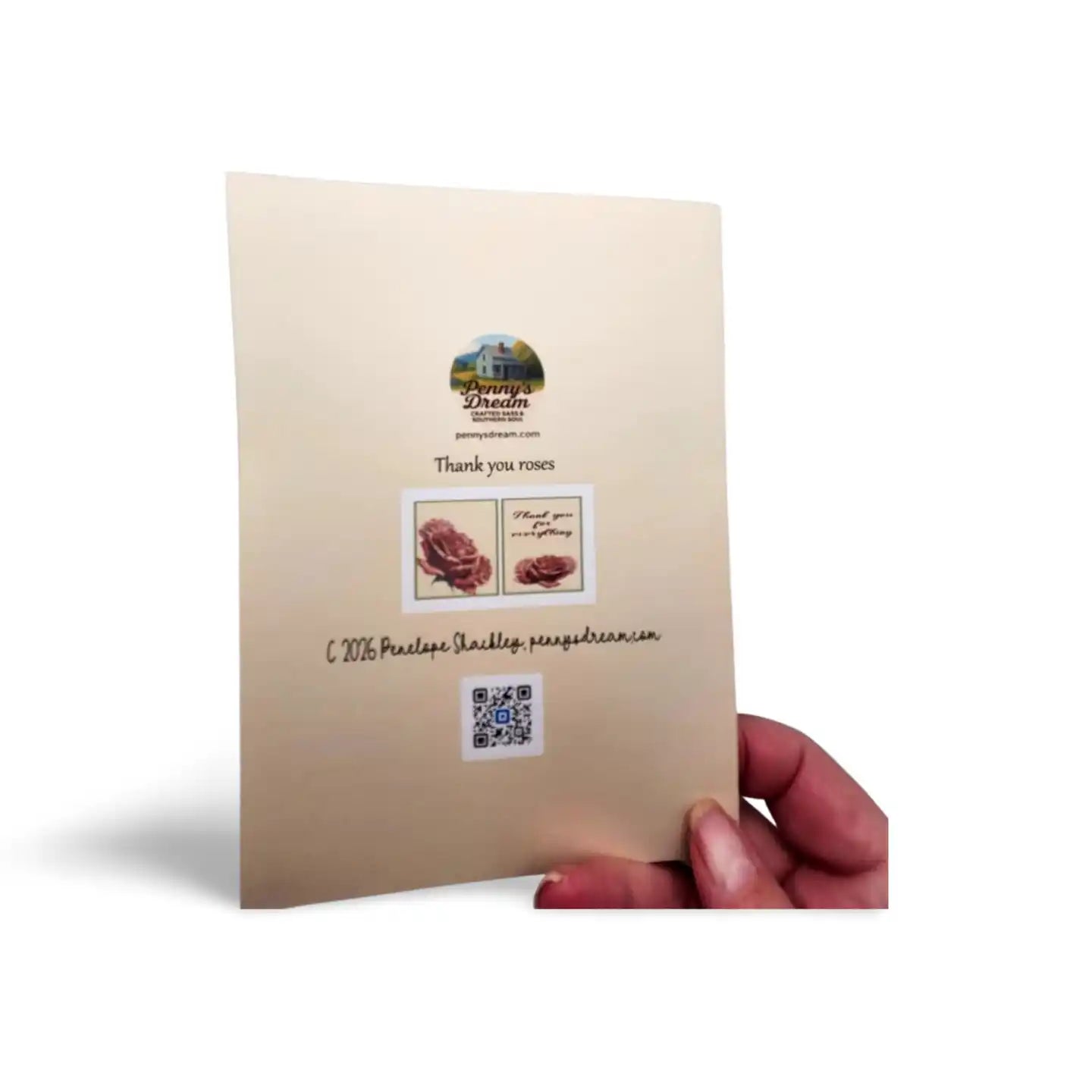 Beige card with floral design and text held by a hand on a white background