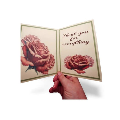 Hand holding a card with roses and 'Thank you for everything' text on a white background