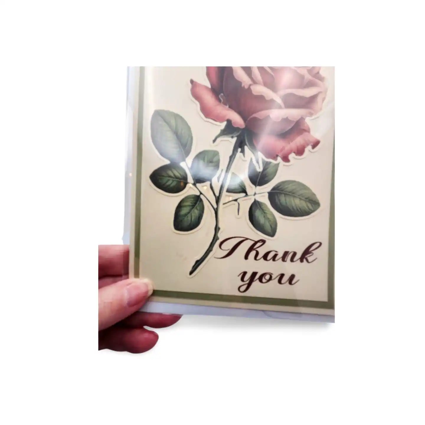 Card with a rose design and 'Thank you' text held by a hand on a white background