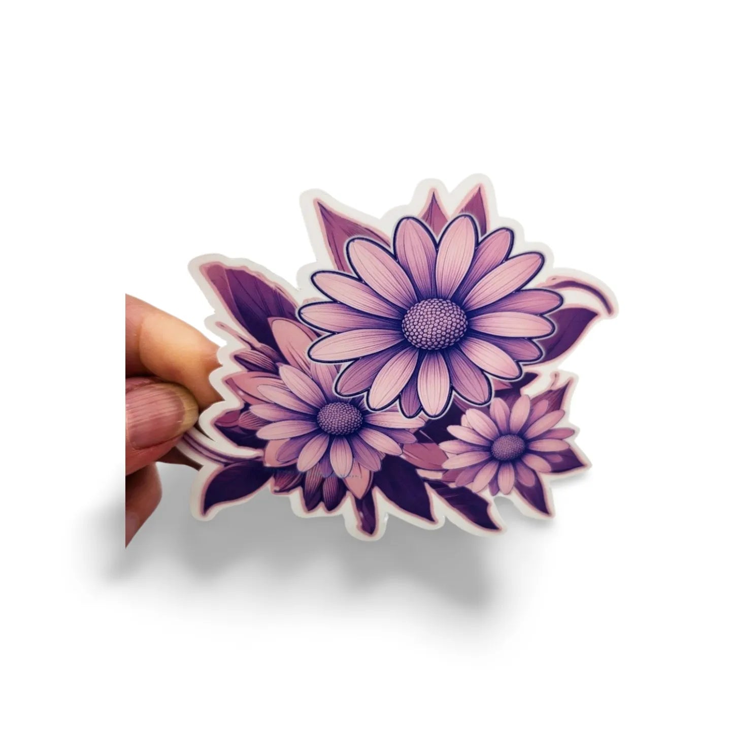 Hand holding a purple floral sticker against a white background
