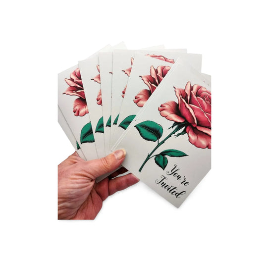Hand holding a set of cards with floral designs and text on a white background