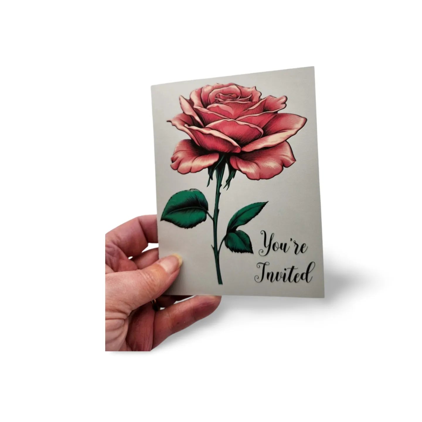 Hand holding a card with a red rose and 'You're Invited' text on a white background