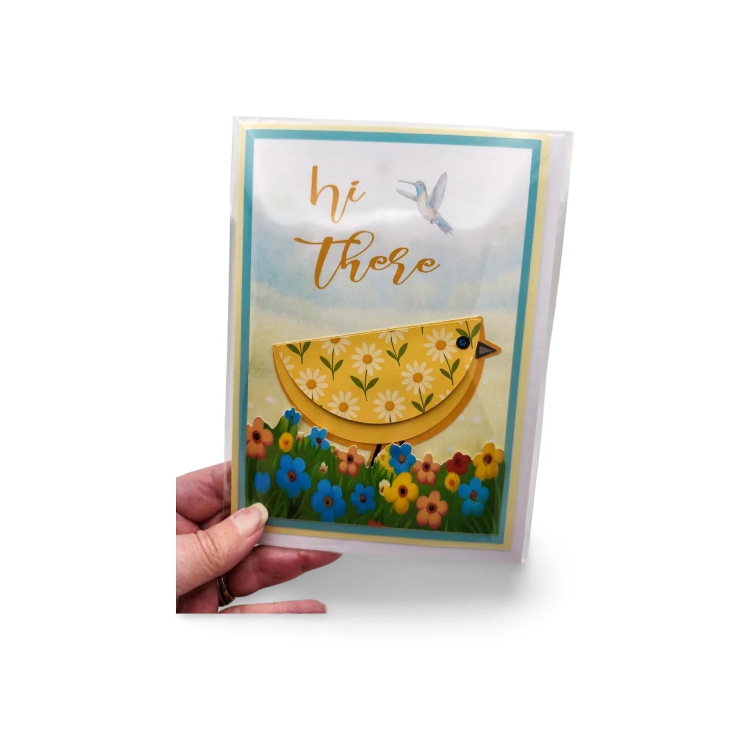 Greeting card with a yellow chick design and 'hi there' text, held by a hand on a white background.