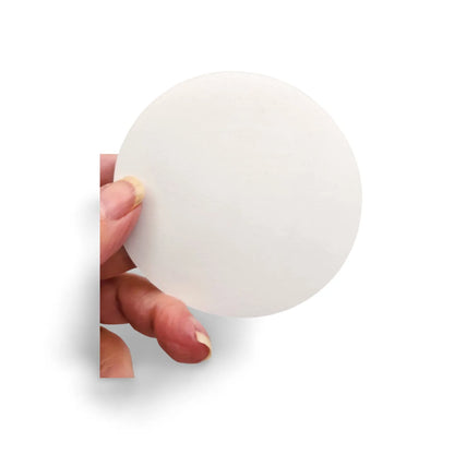 Hand holding a white round object against a white background