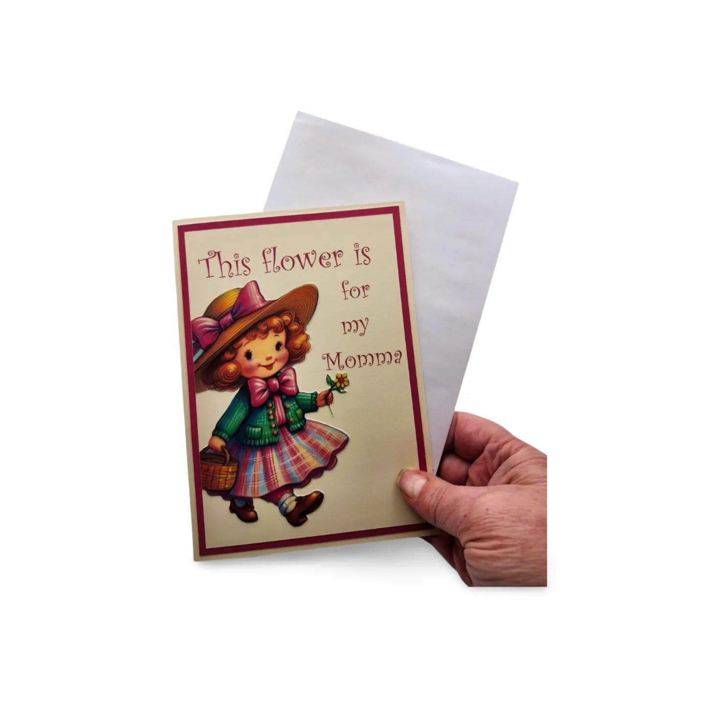 Greeting card with a child holding a flower and text, held by a hand on a white background