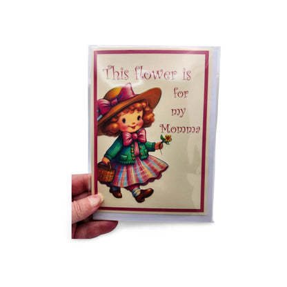 Vintage-style greeting card with a child holding a flower and text 'This flower is for my Mommy' on a white background.