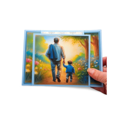 Card with illustration of a man and child walking together in a garden, held by a hand.
