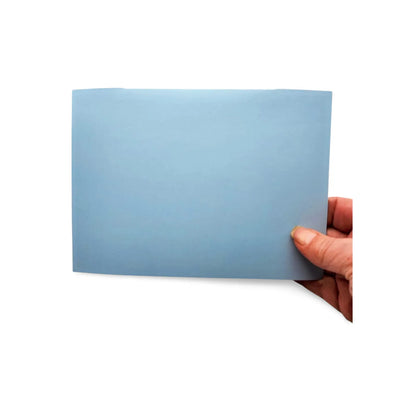 Hand holding a light blue card against a white background
