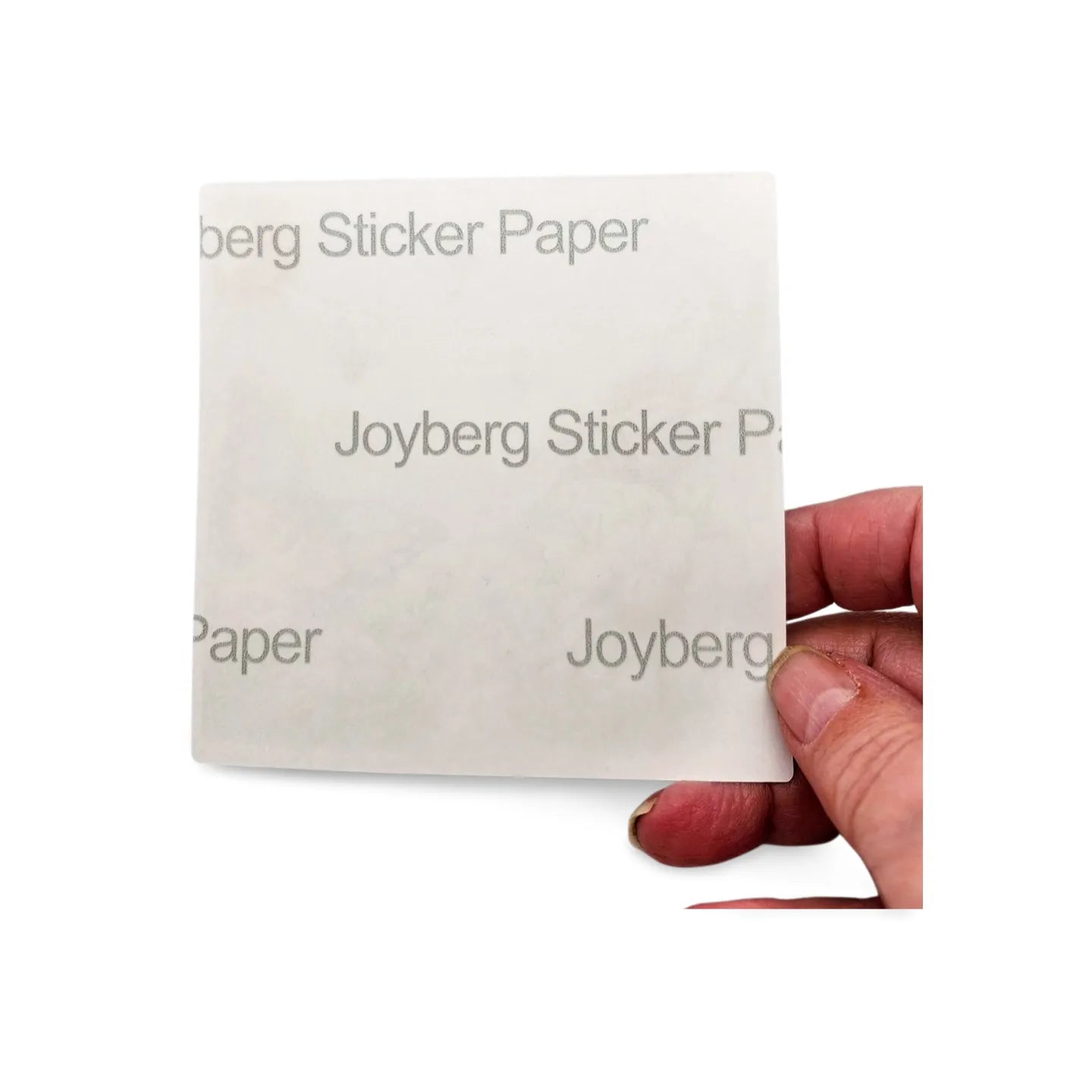 Joyberg Sticker Paper held by a hand on a white background