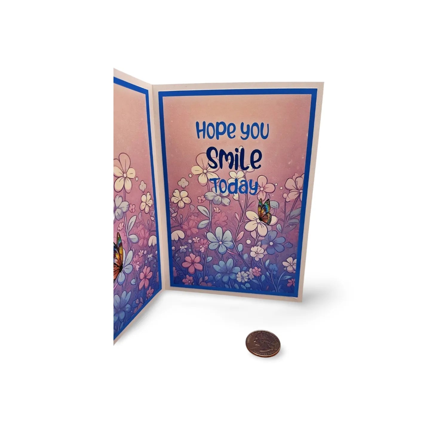 Greeting card with floral design and 'Hope you smile today' text, next to a coin for scale.