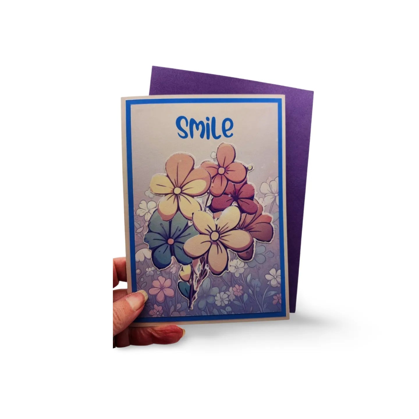 Greeting card with floral design and 'smile' text held by a hand on a white background