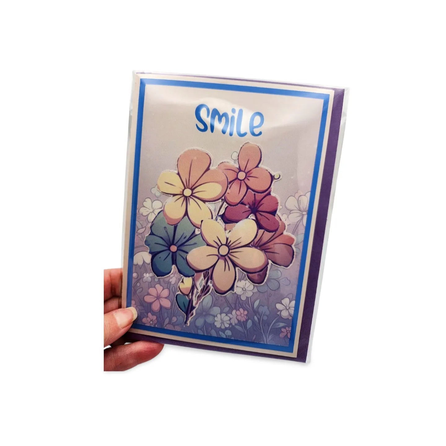 Greeting card with floral design and 'smile' text held by a hand on a white background