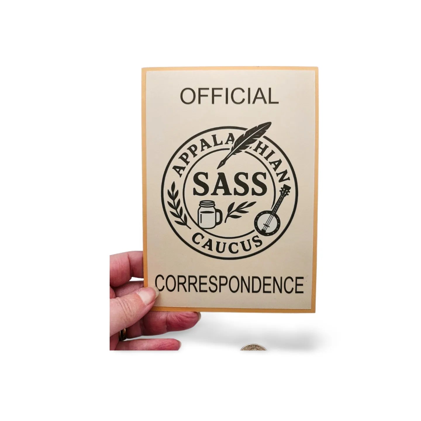 Card with 'Official Appalachian Sass Caucus Correspondence' design held by a hand on a white background