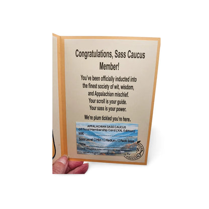 Card with text and a membership card for 'Sass Caucus' held open by a hand on a white background.