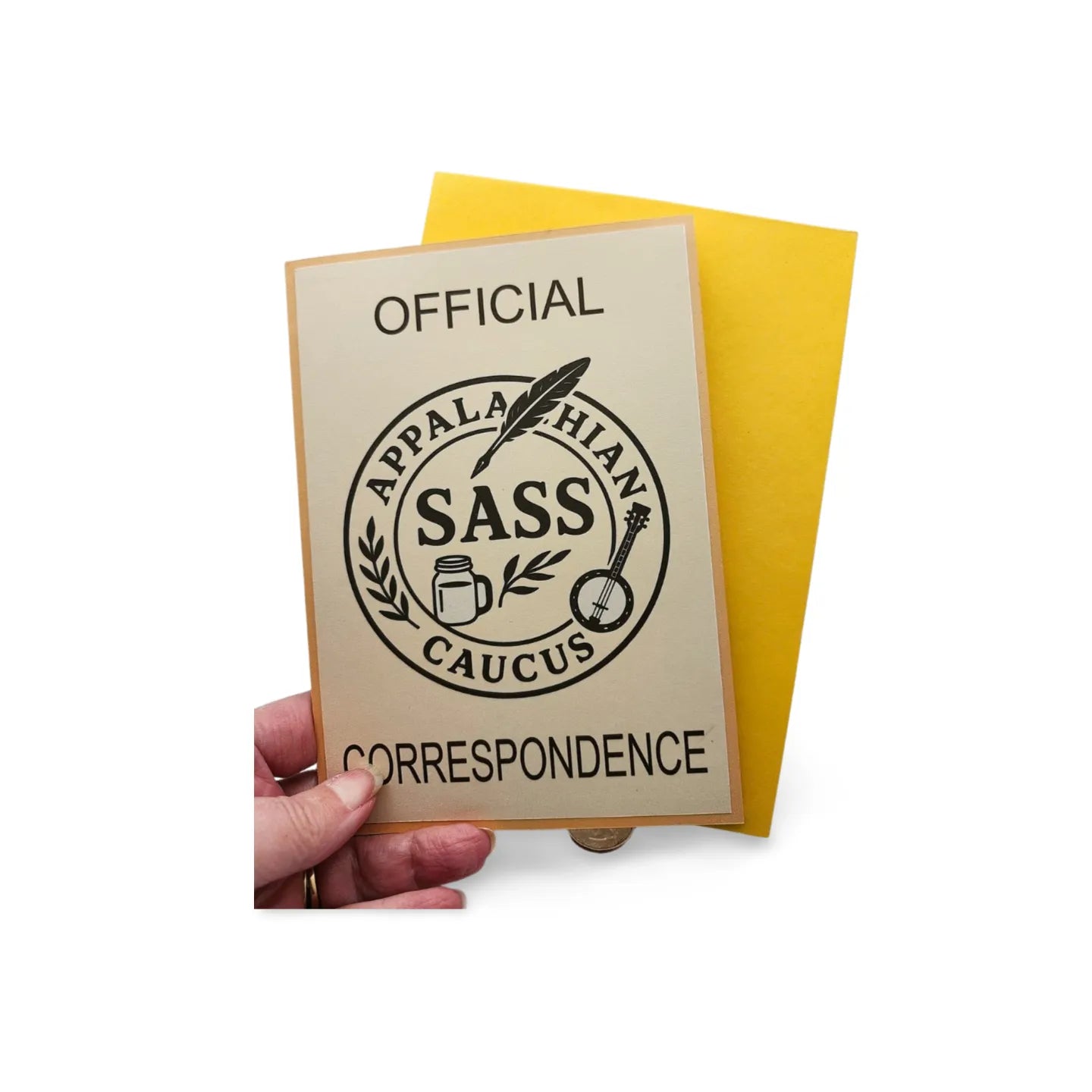 Card with 'Official Appalachian Sass Caucus Correspondence' text and design held by a hand on a white background