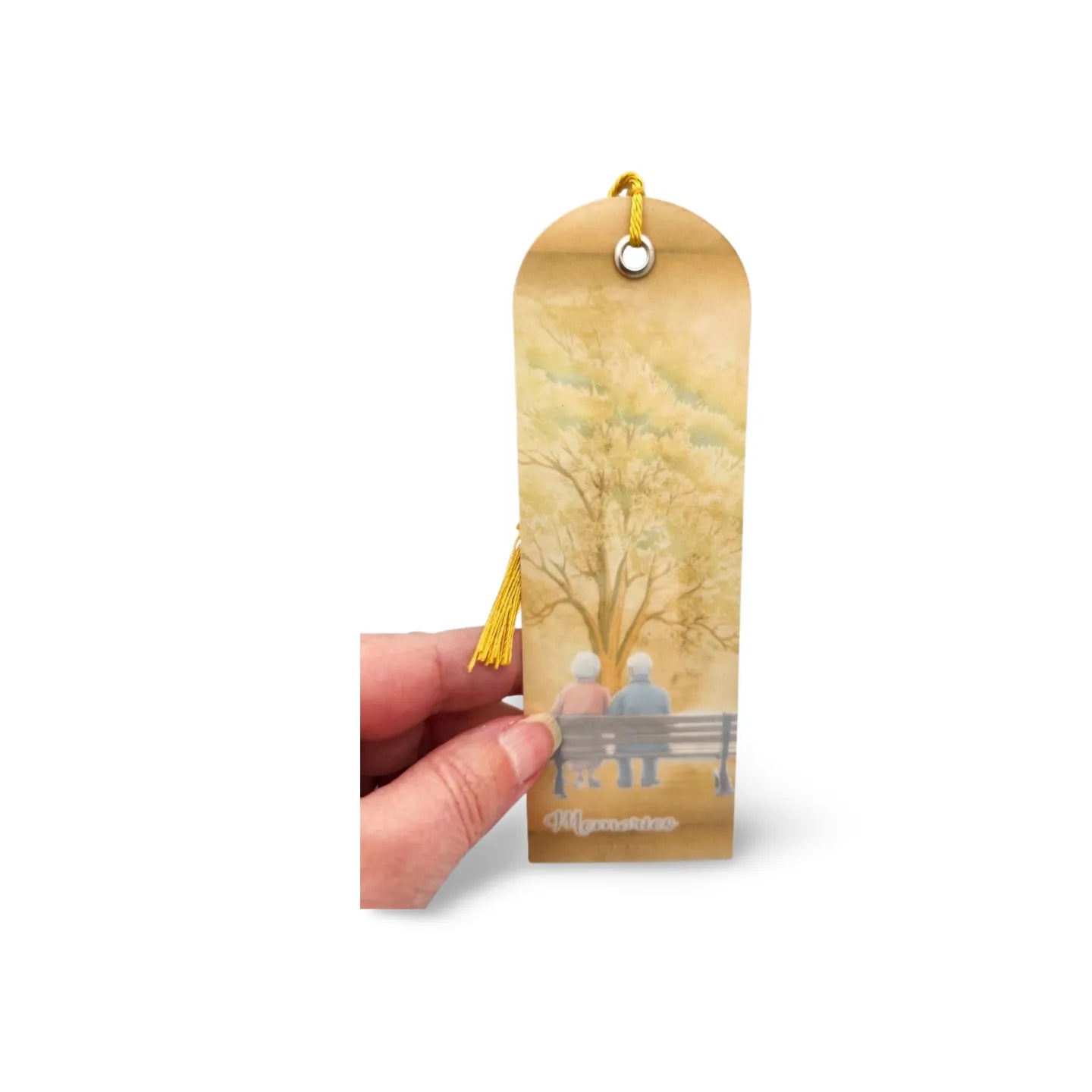 Bookmark with a design of two people on a bench, held by a hand against a white background.