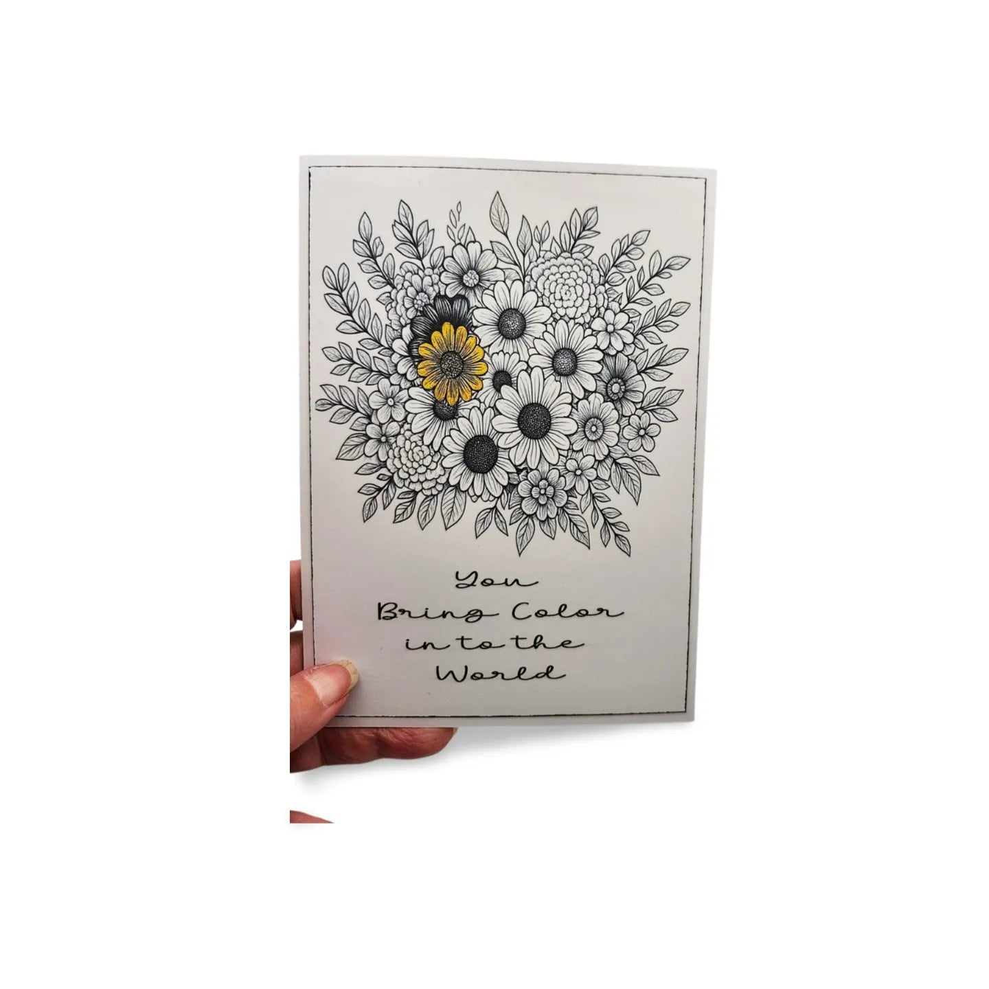 Card with floral design and text held by a hand on a white background