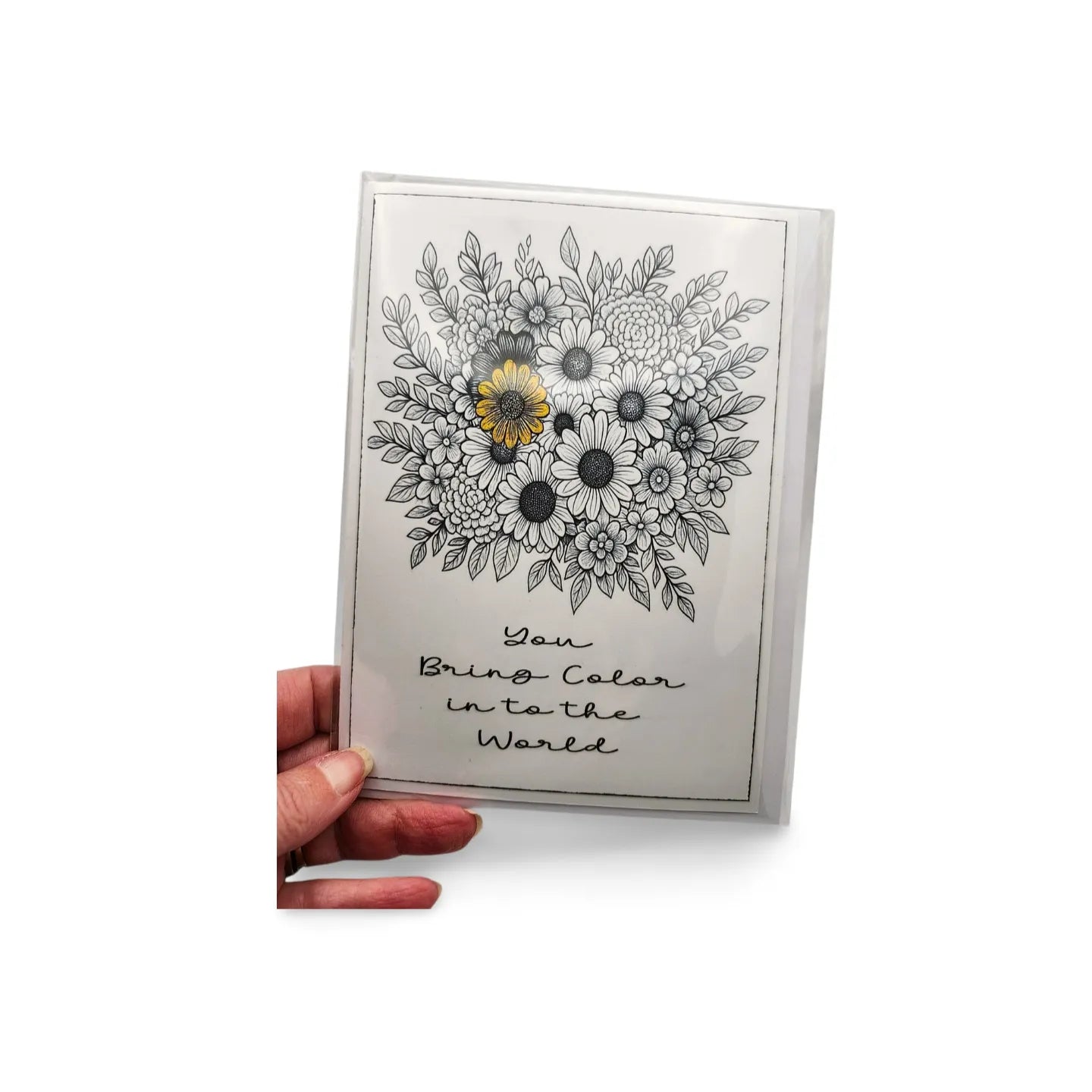 Card with floral design and text held by a hand on a white background