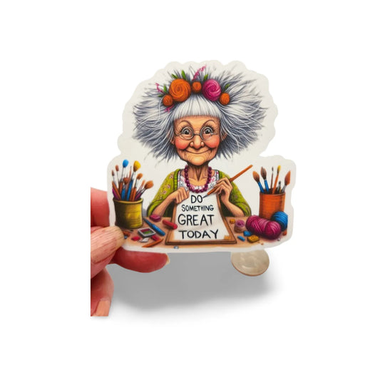 Sticker of an elderly woman with artistic tools and a motivational quote on a white background