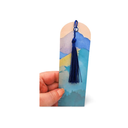 Bookmark with a blue tassel held by a hand on a white background