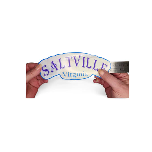 Sticker with 'Saltville Virginia' text held by hands against a white background