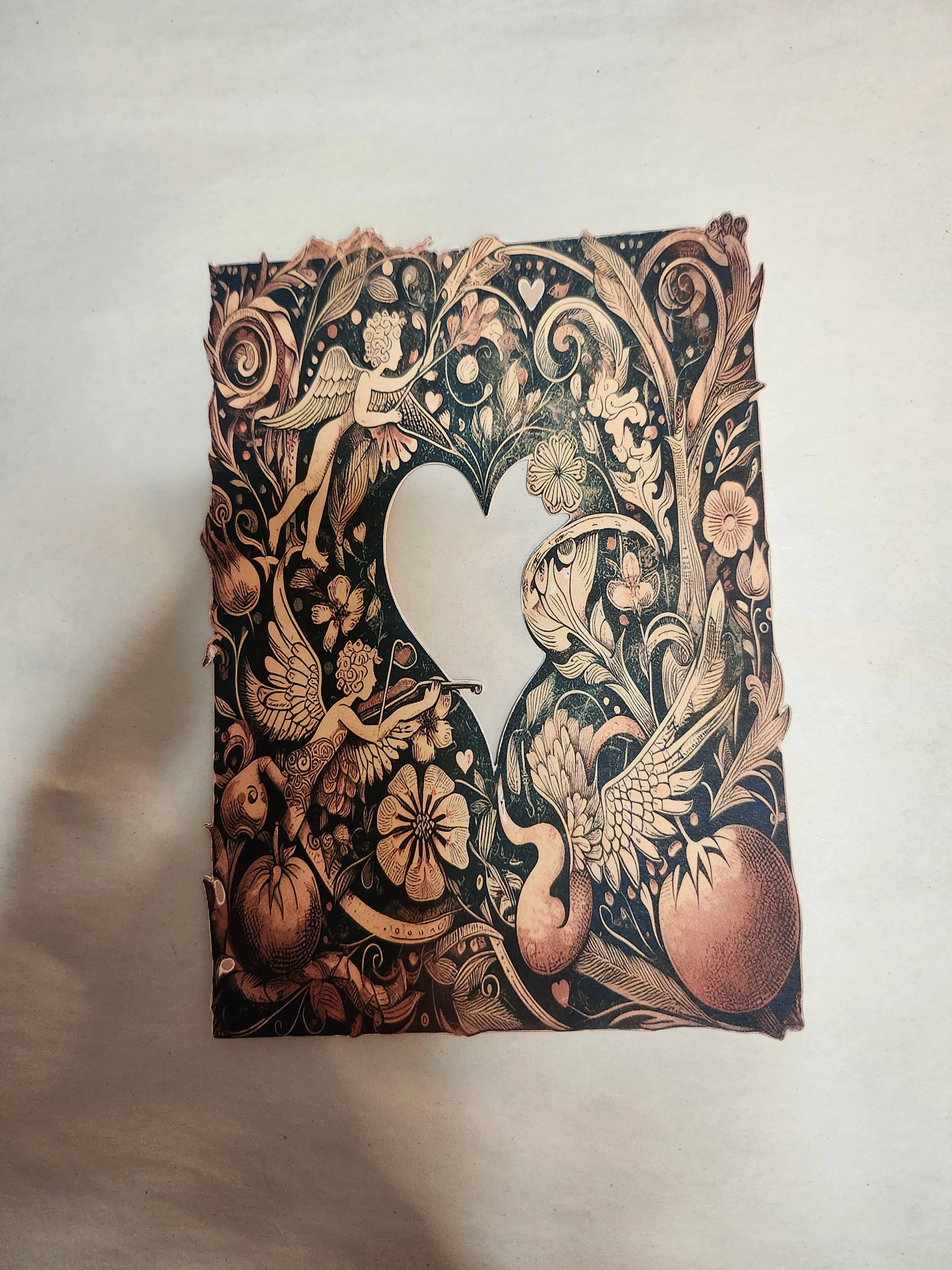 Decorative notebook with intricate black and gold design on a light background