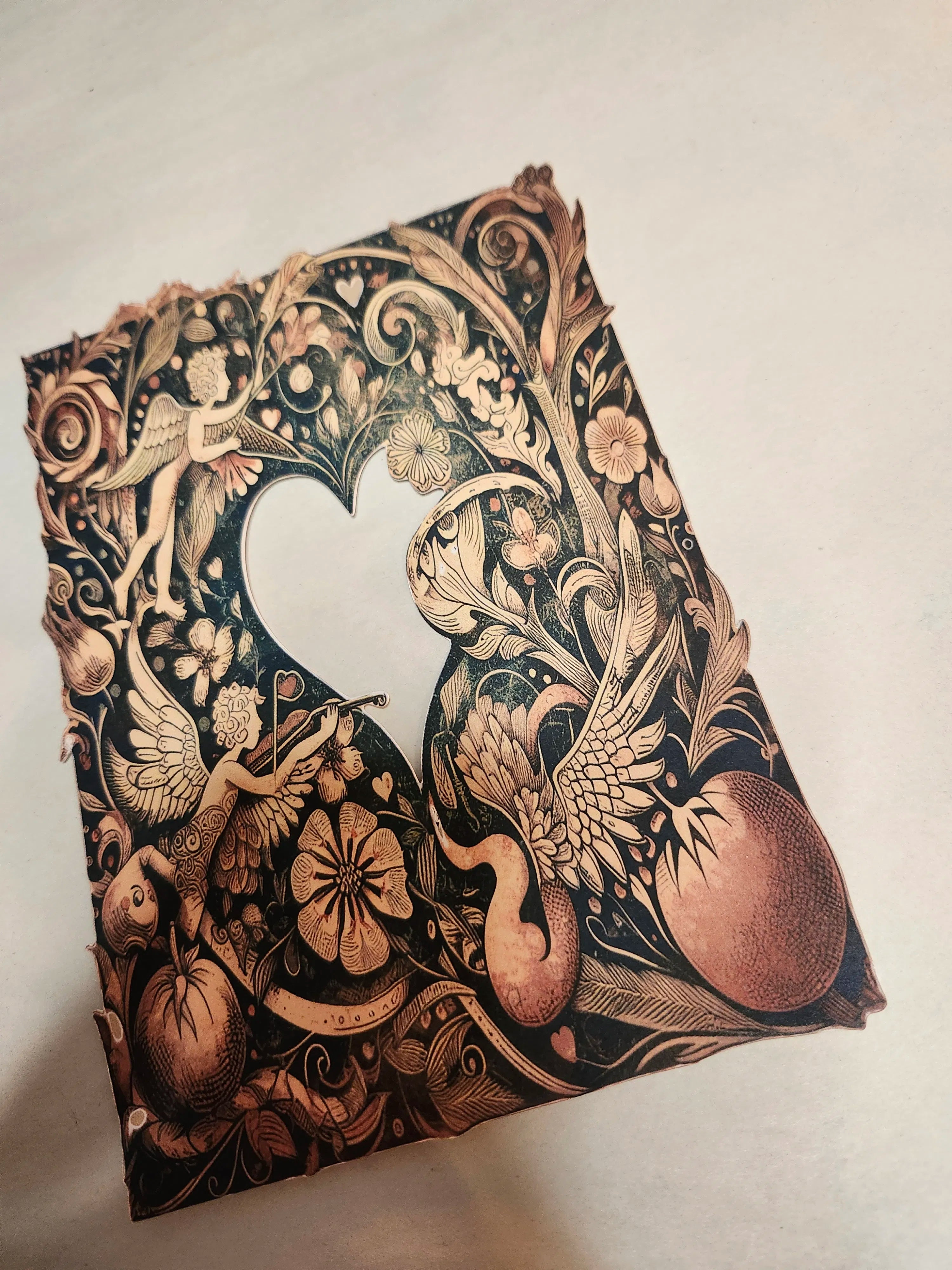 Decorative notebook cover with intricate gold and black designs on a light background