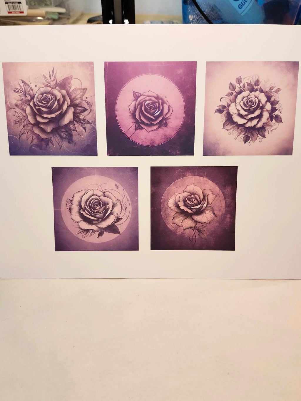 Five purple rose tattoos on a white paper background