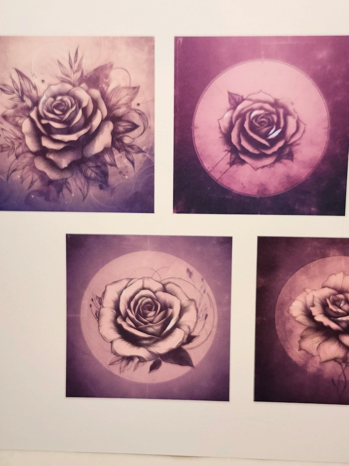 Four tattoo designs of roses on a purple background